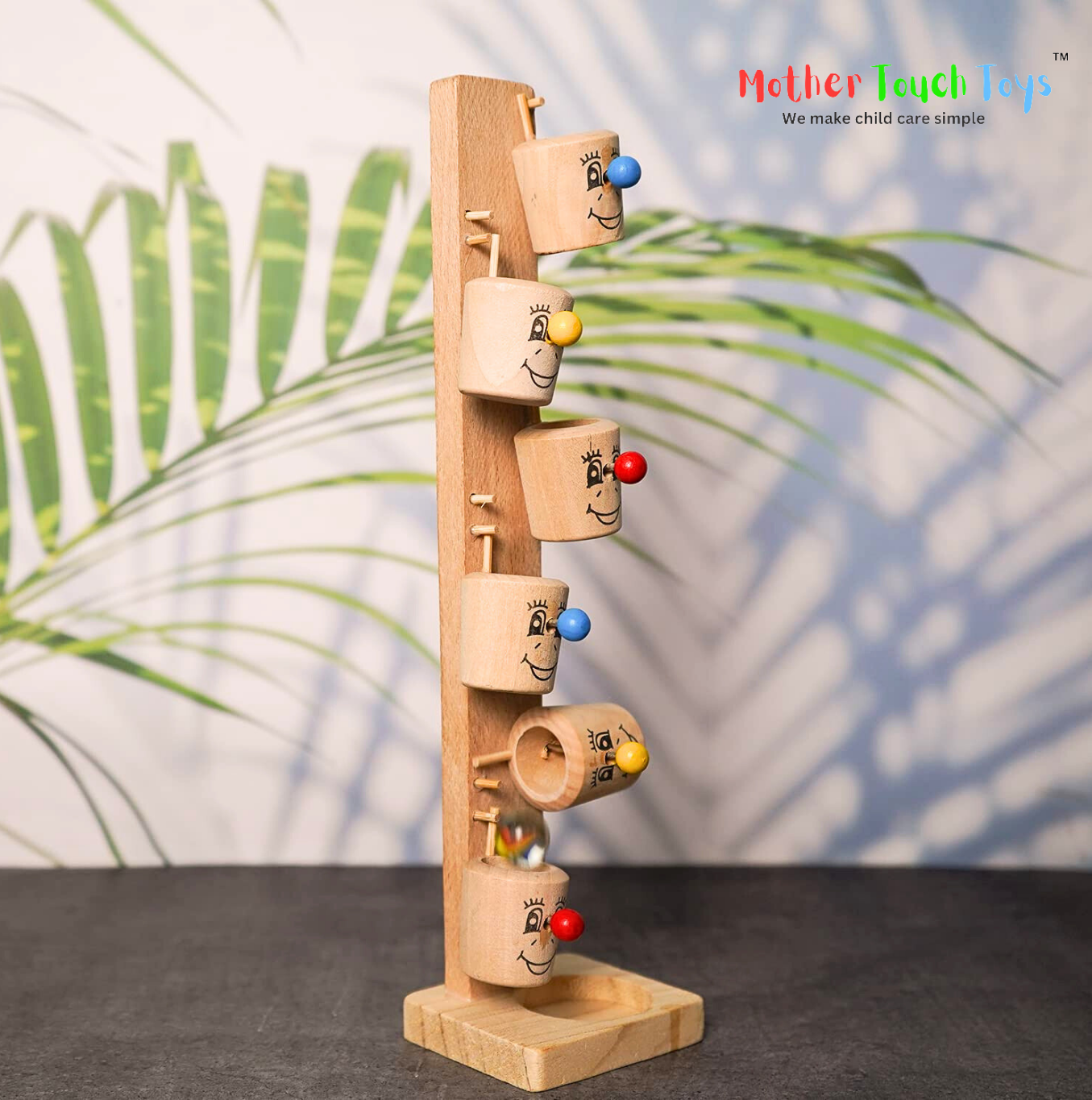 Wooden stacking toy with six colorful cups and three clown faces on a white background. This classic children's toy helps toddlers develop motor skills and hand-eye coordination. 